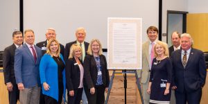 Group of people standing with a proclamation printed out poster size